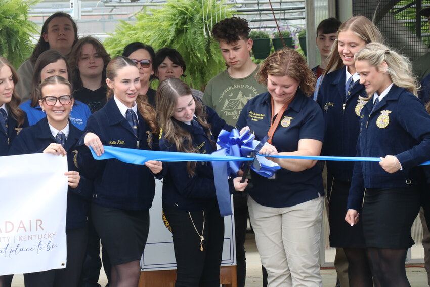 FFA Advisor Brittany Smith with FFA members officially cutting the ribbon for the opening of the greenhouse.