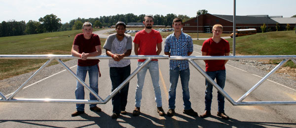 From left, Gabe Cowan, Xavier Mathis, Corey Melton, Justin Brockman, and Dillion Oglesby-Graves at the entrance of Adair County Primary Center, behind the gate they recently finished welding.