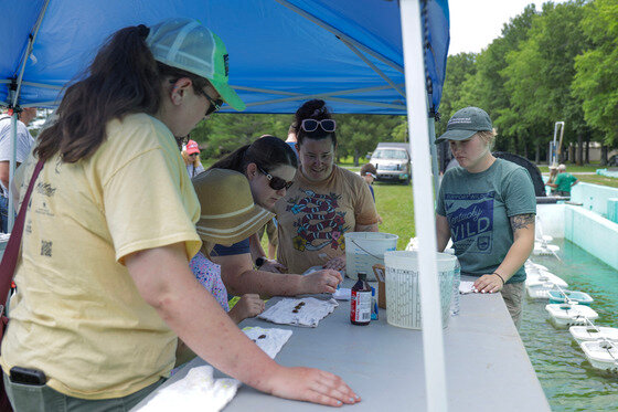 During a Kentucky Wild Member Experience, fisheries biologist Julieann Jacobs (center) teaches attendees how to glitter-tag native freshwater mussels raised at Minor Clark Fish Hatchery. KDFWR photo.