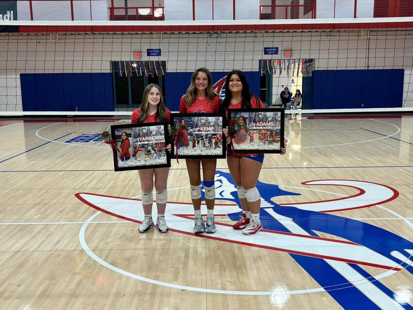 Riley Yarberry, Jazlyn Kemp, and Lily Adams beam after receiving their commemorative plaques for Senior Night.