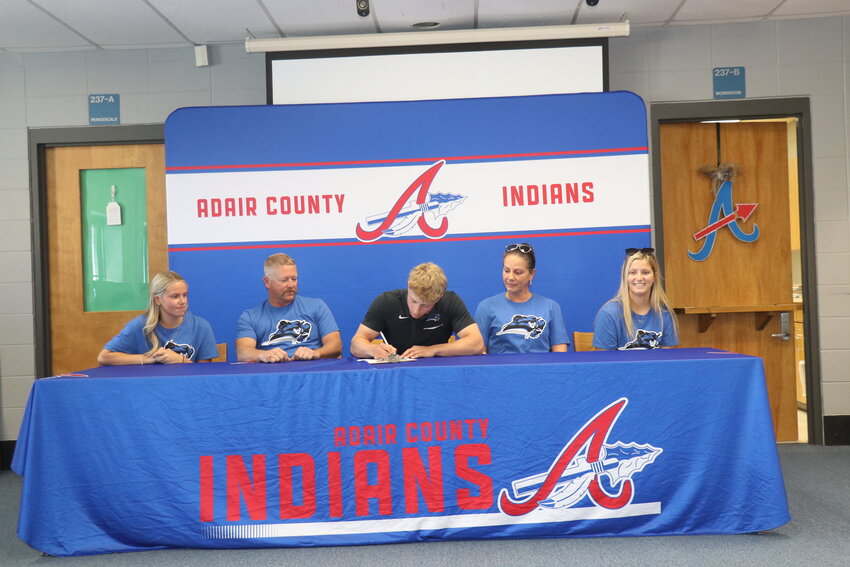 Zane Gist signs his National Letter of Intent surrounded by his parents and sisters.