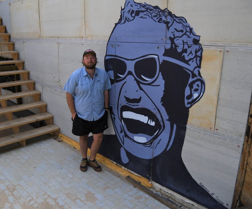 Mark Bertel stands next to a painting of Ray Charles in the courtyard of the Baker Street Market in downtown Mountain Home. The open-air market, which will include Rio Burrito, is being built in the lot that previously housed the Old Tyme Restaurant.