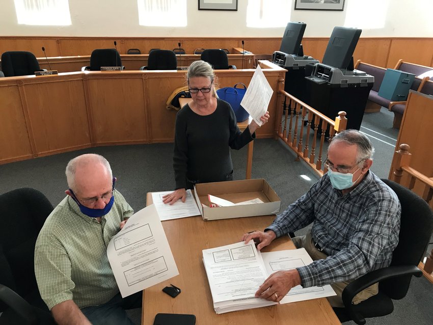 Members of the Baxter County Election Commission, from left, Bob Bodenhamer, Judy Garner and Rick Peglar review a stack of provisional ballots Wednesday morning at the Baxter County Courthouse.