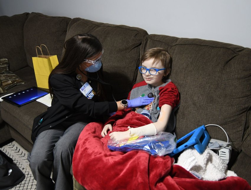 Baxter Regional Home Health nurse Angie Knight examines 9-year-old Bo during a home visit on Nov. 16. Baxter Regional officials say 20 to 25 percent of their home health patients fall outside senior citizen age range.