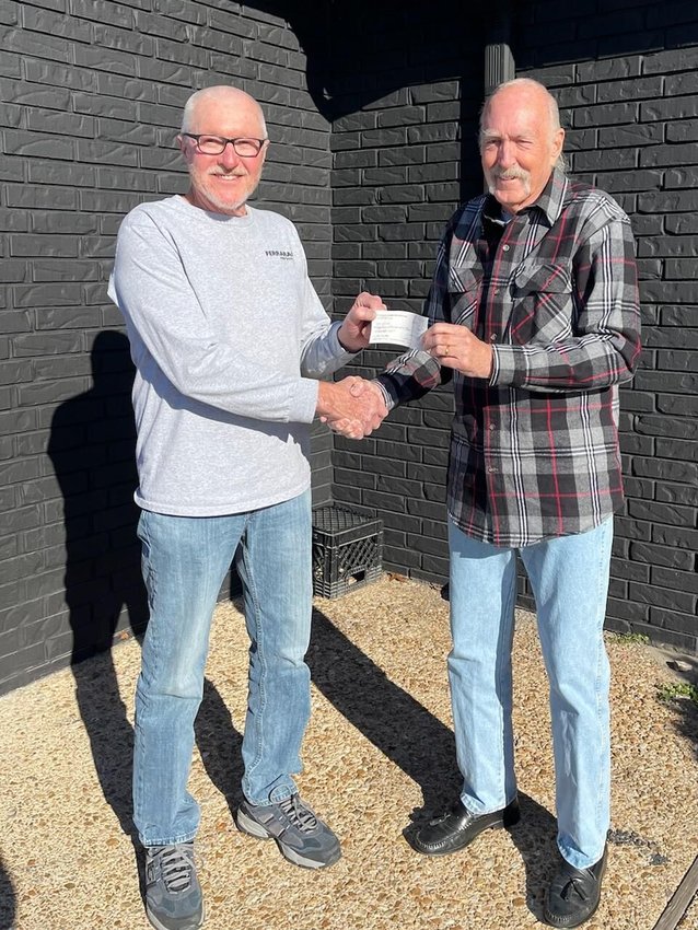 Northeast lakeside Fire Association Chief Henry Porter (left) accepts a $25,000 donation from Northeast Lakeside Fire Association Auxiliary President Hart Rowland. The donation was funded by the generosity of  auxiliary members and Internet sales of large, donated items.