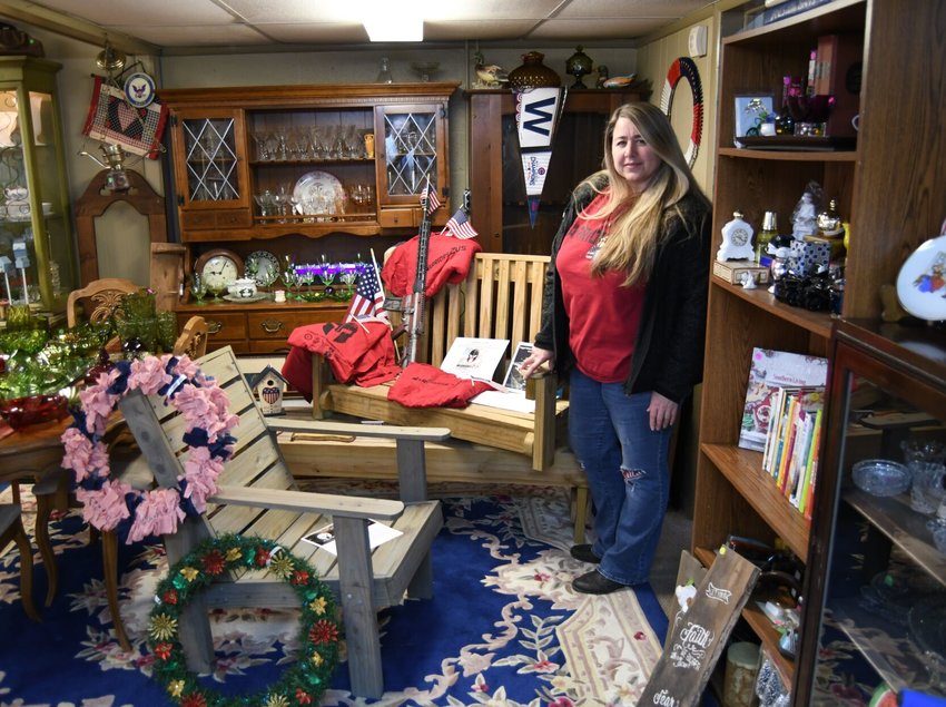 Donna Nasr, founder and president of Warriors2Us, stands next to a deck chair, bench and porch swing that was recently on display at Wow Extraordinary Gifts in Mountain Home. The organization is selling the veteran-made items as a fundraiser to help support its recreational camp in Hardensville, Mo., for veterans and first responders.