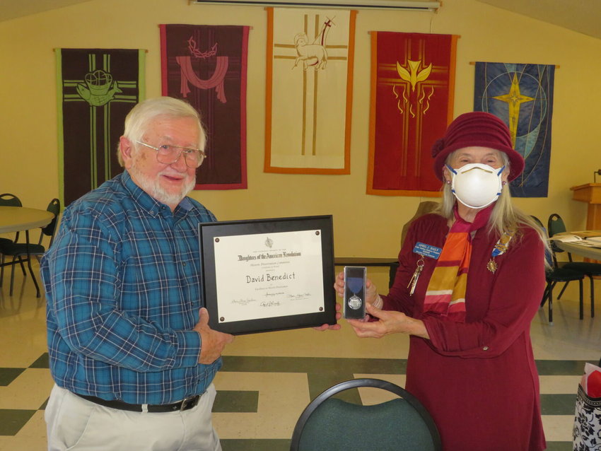 David Benedict, president of the Baxter County Historical and Genealogical Society, receives the Daughters of the American Revolution's Excellence in Historic Preservation Certificate and Medal from April Baily, Captain Nathan Watkins DAR Chapter regent.