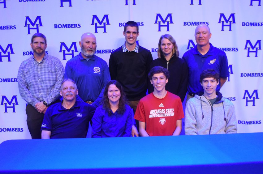 Mountain Home's Andrew Westphal (front row, third from left), pictured with family and coaches, signed Wednesday with Arkansas State University for cross country and track and field.