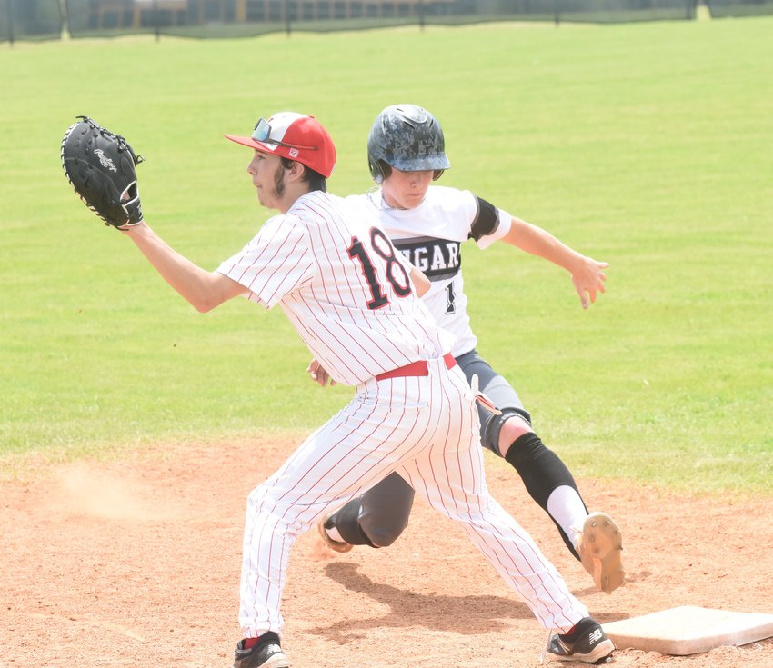 Izard County's Denton Reliey jumps back to first base as Norfork's Erik Foster awaits the throw on Friday.