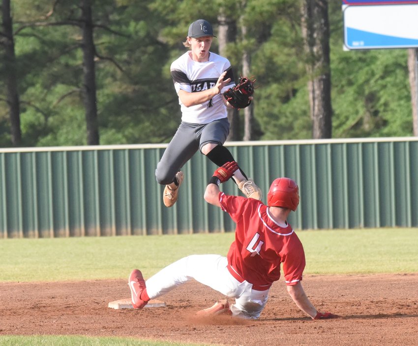 Izard County shortstop Denton Reiley skies to grab the throw on a stolen base attempt by Nemo Vista on Friday night.
