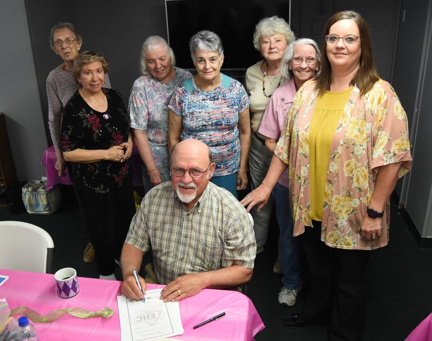 Baxter County Judge Mickey Pendergrass signs the proclamation naming May as Arkansas Extension Homemakers Month in front of members of the Patchwork EH Club on May 9.   Scott Liles/The Baxter Bulletin