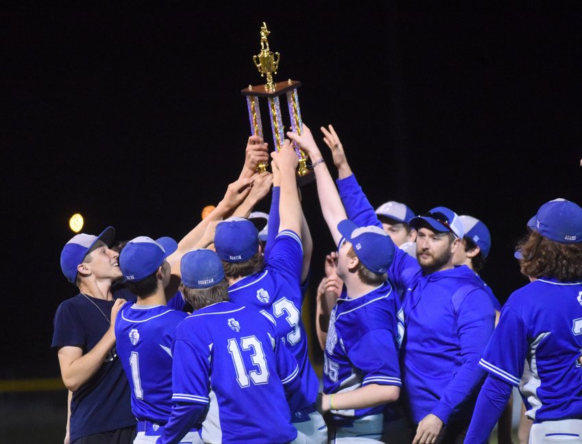 Members of the Cotter Warriors hoist the 2A-1 District championship trophy.