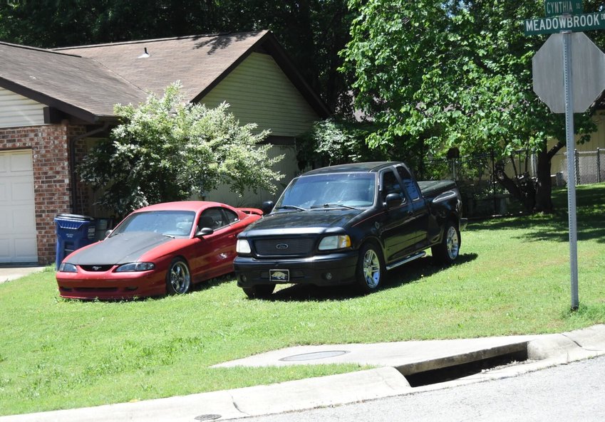 A pair of vehicles sit parked in the yard of a residence at the corner of Cynthia Square and Meadowbrook Drive in Mountain Home last month.   Scott Liles/The Baxter Bulletin
