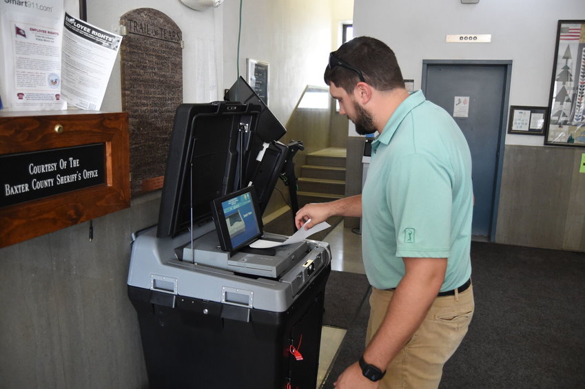 Howie Wehmeyer feeds his ballot into the tabulator after voting Monday in the special election to approve or deny the Mountain Home School District's proposed millage increase.   Scott Liles/The Baxter Bulletin