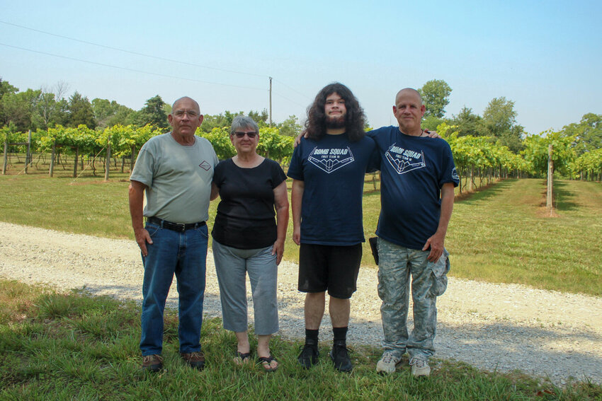 Tony Chamberlain (from left) Susan Chamberlain, Jordan Ellison and Steve Ellison stand in front of the Faraway Vineyard in Gamaliel, home to the Baxter County Farm Family of the Year.   Ethan Granniss/Special to The Bulletin