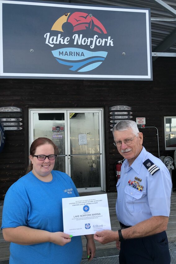 James Zimmerman of the Flotilla 5-7,&nbsp; Twin Lakes Flotilla, USCG Auxiliary,&nbsp;presents a plaque memorializing P. Donely Morrison to Katosha Johnson, Lake Norfork Marina manager.   Submitted Photo