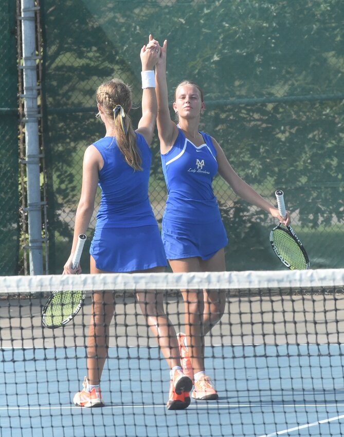 Mountain Home's Nadia Talbot (right) and Bianca Talbot celebrate a point during a recent home match. The Lady Bombers earned a victory over Harrison on Thursday.