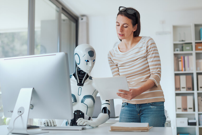 Woman and AI robot working together in the office, automation and technology concept