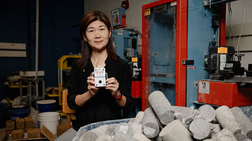 Wavelogix CEO and Purdue University professor Luna Lu holds the REBEL Concrete Strength Sensing System, which her lab invented to improve estimates of in-place strength of concrete structures. Wavelogix, founded by Lu, has received a $999,910 SBIR grant to develop the technology.