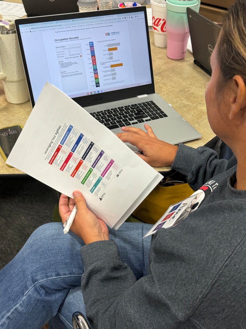 A career coach reviews materials during a training session.