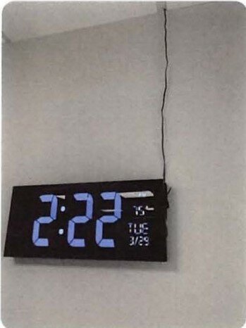 One of the AcuRite LED clocks hangs in a ninth-floor office. The electrical receptacle can be seen above the clock where it is plugged into the ceiling.