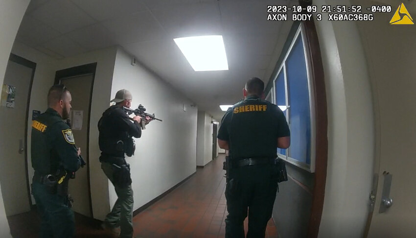 Unidentified Alachua County Sheriff's Office deputies, armed with assault rifles and pistols, are seen in newly released police body camera video searching the University of Florida Turlington Hall classroom building Oct. 9, 2023, after a a panicked stampede during a nighttime vigil on campus for Israelis killed in Hamas attacks. Police later concluded the students panicked because a woman in the crowd had fainted and her boyfriend shouted for others to call 911, not because of gunfire or an explosion. (University of Florida Police Department/Fresh Take Florida).