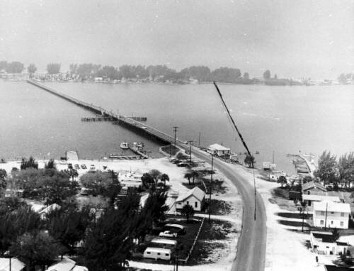 Aerial photo of the old wooden bridge with a projection line of new bridge drawn on photo, circa 1950s.