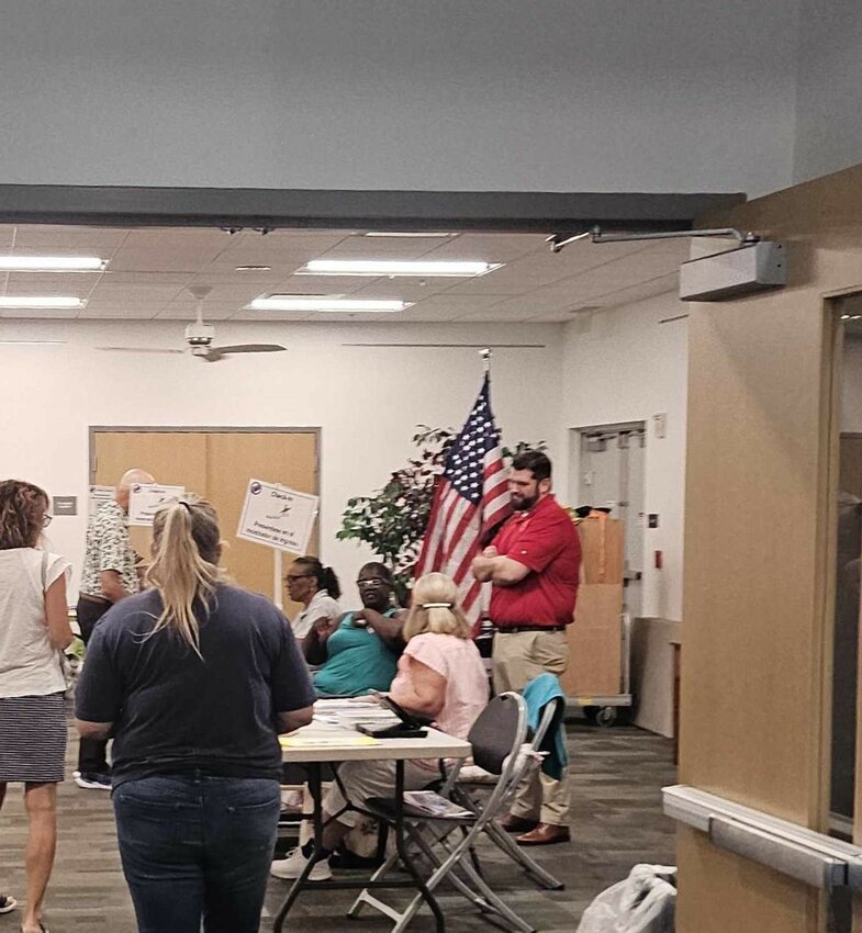 Supervisor of Elections candidate James Satcher stands behind the poll workers’ station at the Palmetto Branch Library early polling location.