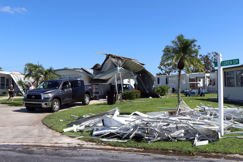 Residents in Orange Acres work on fixing a badly damaged home in Sarasota, Fla., Oct. 12, 2024. The manufactured house had its roof caved in during Hurricane Milton, after the community suffered an earlier blow from Helene. (Kylie Williams/WUFT News)