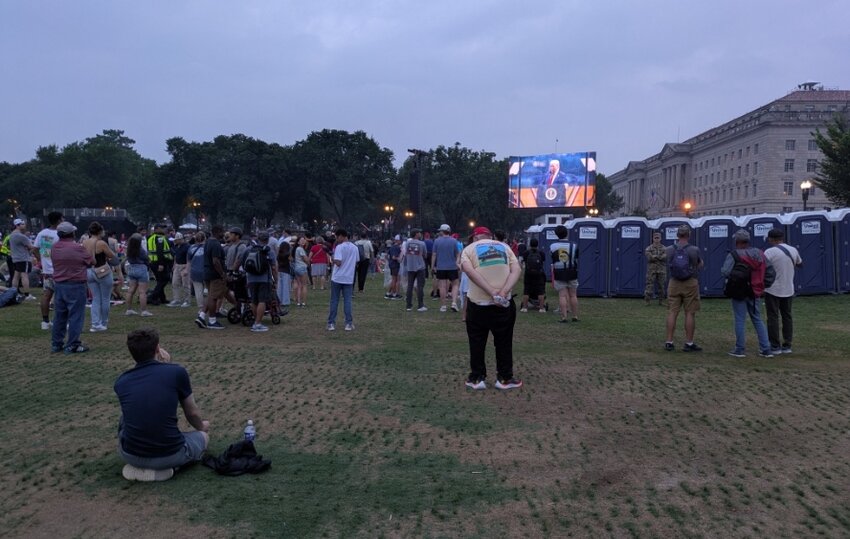 President Donald Trump’s speech was displayed on large screens as people watched near the Washington Monument at the conclusion of the Army parade on June 14, 2025. (Photo by Ashley Murray/States Newsroom)