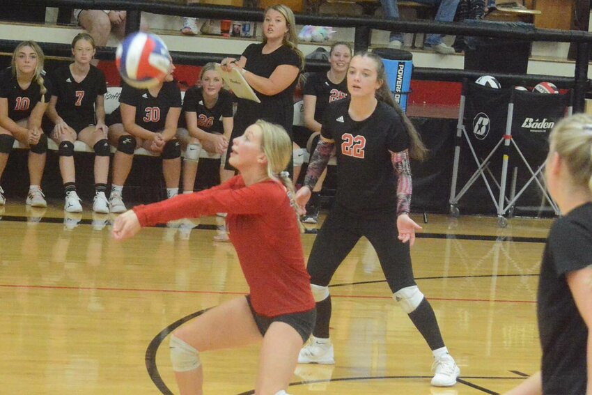 Kadence Wilson (in red shirt) was all over the floor against Crane, as illustrated here by her bump shot. She also served 12 consecutive points in the second set. Also pictured is Ella Myers (22).