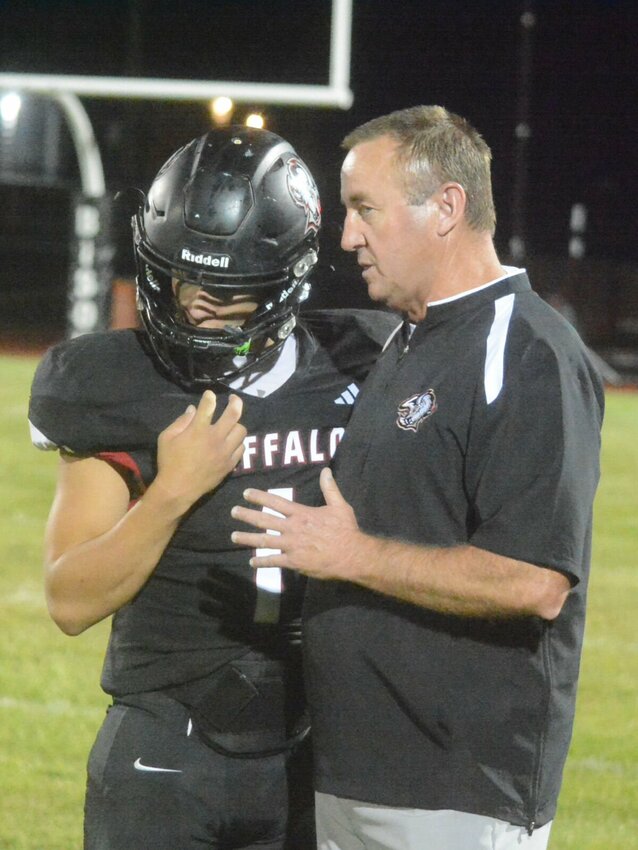 Coach Ed Phillips talks strategy with Buffalo quarterback Isaiah Young before the start of the second half. It must have worked because Young had a great passing night and scored two touchdowns in the overtime periods.