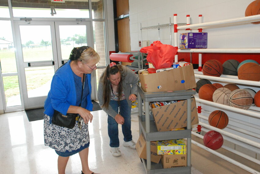President, Donna Goeser and Secretary, Jennifer Kyle stocking food and personal hygiene items for students.