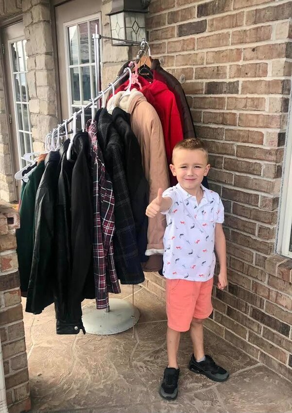 Case Miller, son of Amber Miller, helping his mom put out the coat rack.
