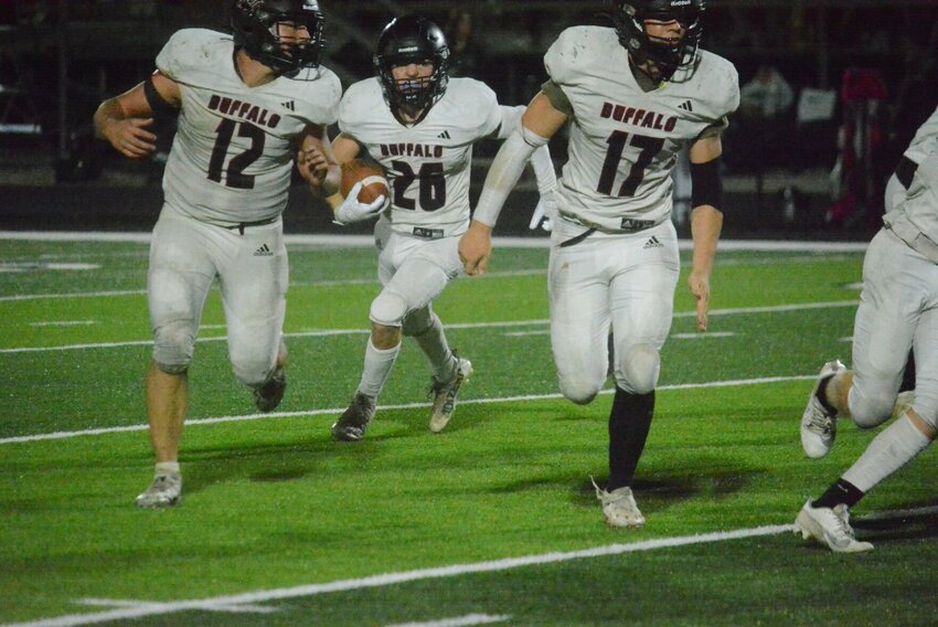 Mathew Skinner (26) runs the ball against Warsaw with the help of blockers Brad Mankey (12) and Ben Foree (17).