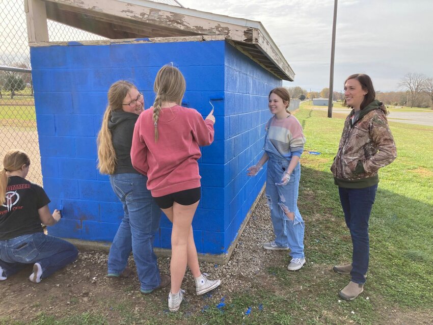 Hollie Elliott, economic development director overseer of GROBuffalo, meets students from DCTC as they work on the dugouts.