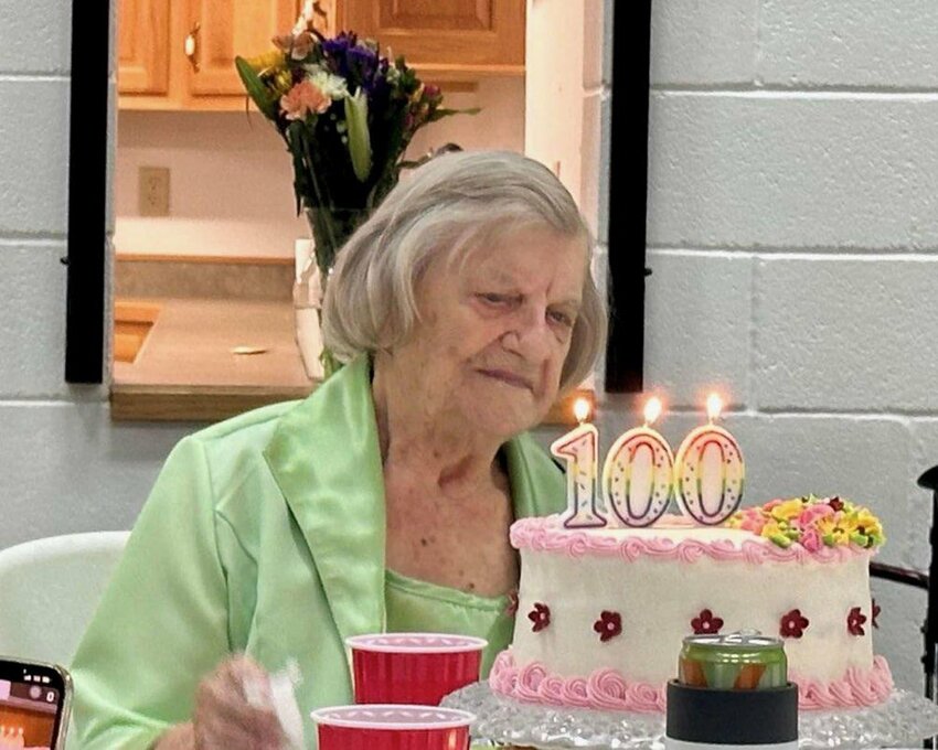 Maxine Hume prepares to blow out the candles on her birthday cake celebrating 100 years this week.