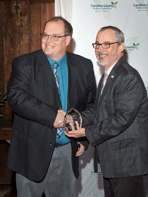 Andrew Buffenmyer, left, receives the 2025-2026 Teacher of the Year award from CCPS Superintendent Dr. Derek Simmons.