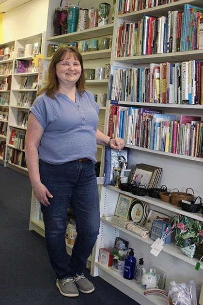 Laura Lewis, owner of the What's New Shop, in front of racks of Christian based literature.