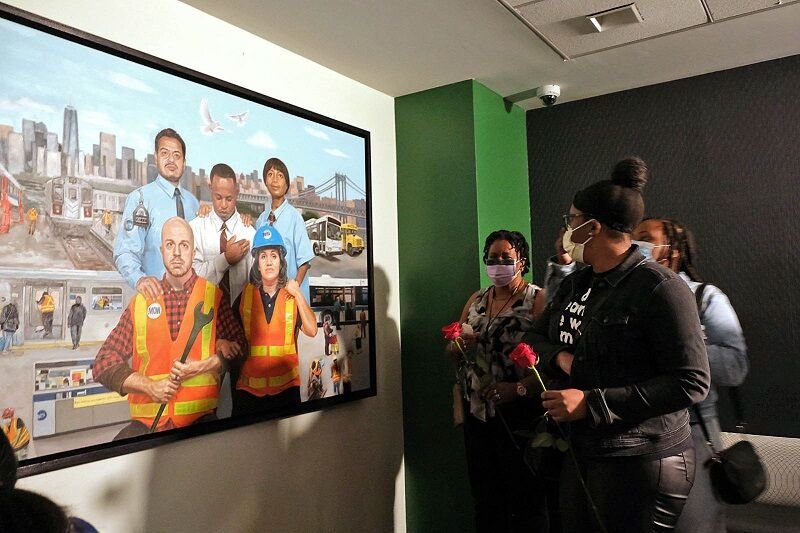 HONORING THOSE WHO GAVE THEIR LIVES: Some of the widows of transit workers who died after being exposed to the coronavirus at work examine a painting of transit workers by Taha Clayton that is part of the memorial that also identifies those who died and their work locations, which was unveiled Sept. 30.