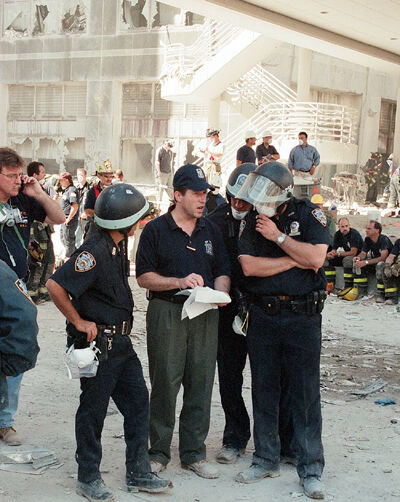 'KEEP TELLING THAT STORY': Patrick J. Lynch was two years into his tenure as president of the Police Benevolent Association on Sept. 11, 2001. He and his union colleagues were at the site when the towers collapsed. For months, Mr. Lynch and other PBA officials returned every day before daybreak. Their tasks there were manifold. The mission now, he said, is to not let the collective memory fade. Above, Mr. Lynch, center, confers with officers shortly after that morning regarding colleagues who went missing. 