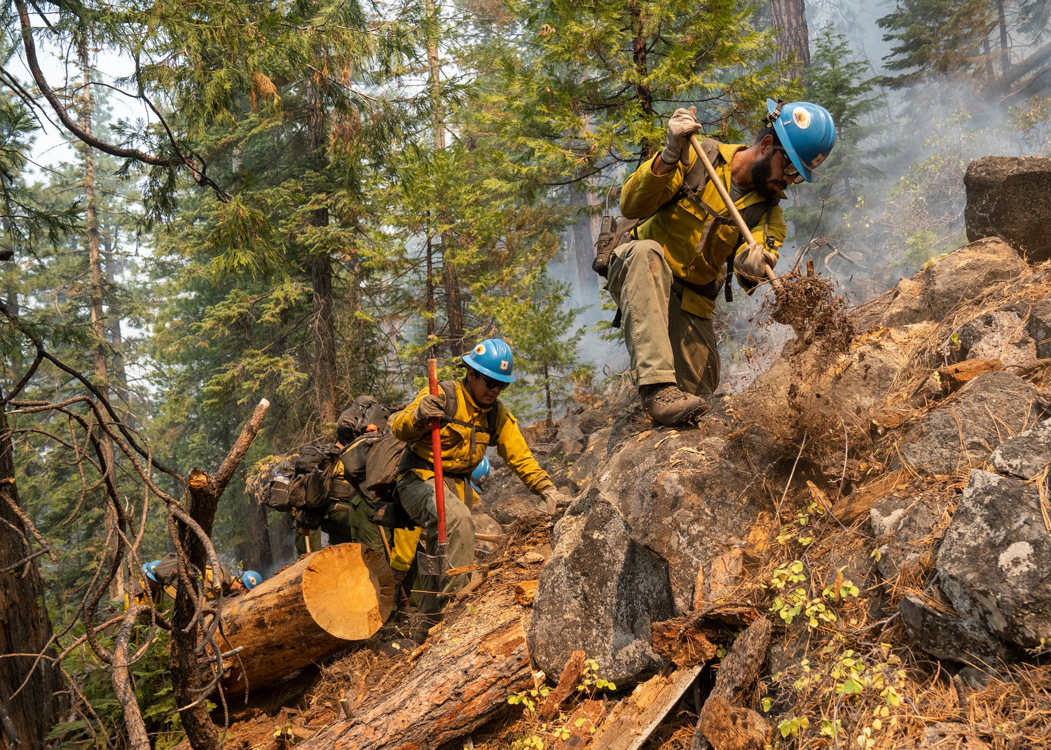 Blue Ridge Hot Shots dug a fireline on a steep-sloped mountain to suppress the Dixie Fire in Lassen National Forest, California, in September 2021. Federal firefighting agencies are experiencing ‘a mass exodus of people,’ among them experienced fire captains and hotshot superintendents, because of low pay, one union official said. A bill that would ensure expiring pay raises are make permanent is languishing in Congress.