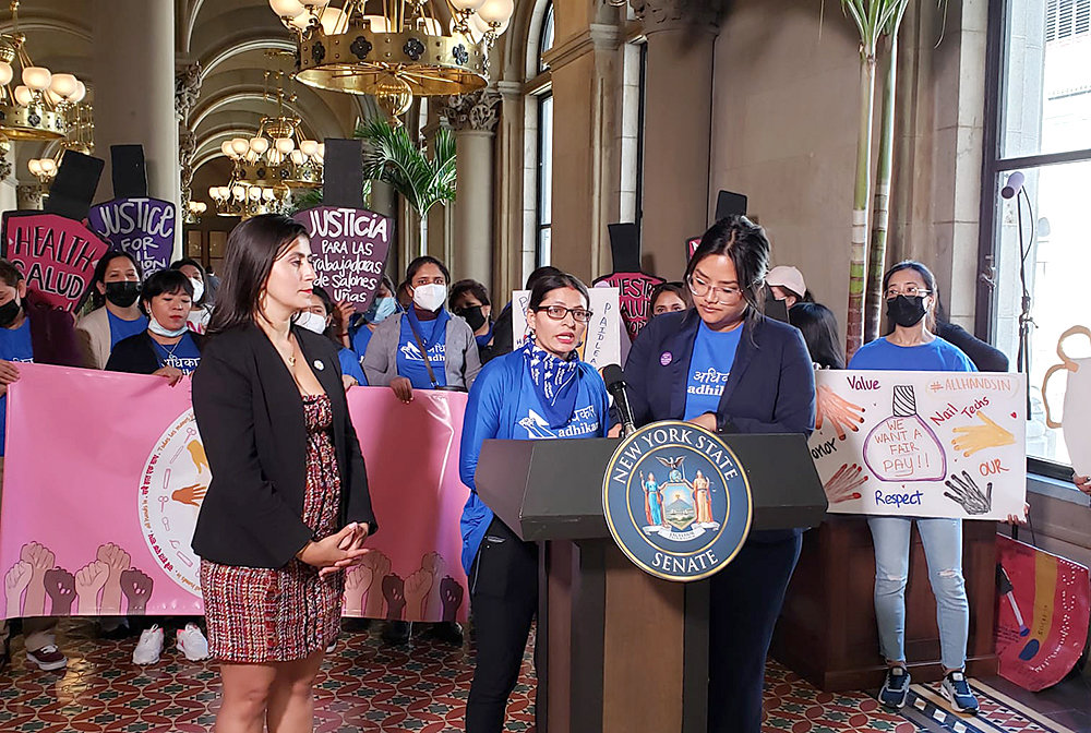 Nail technician Menuka Simkhada, left at mic, spoke of the low pay most nail salon workers receive at a May 24 press conference in Albany. Nail salon workers are backing a proposed bill, sponsored by State Senator Jessica Ramos, at left, that would establish a council to recommend a minimum wage and safety standards for the industry.