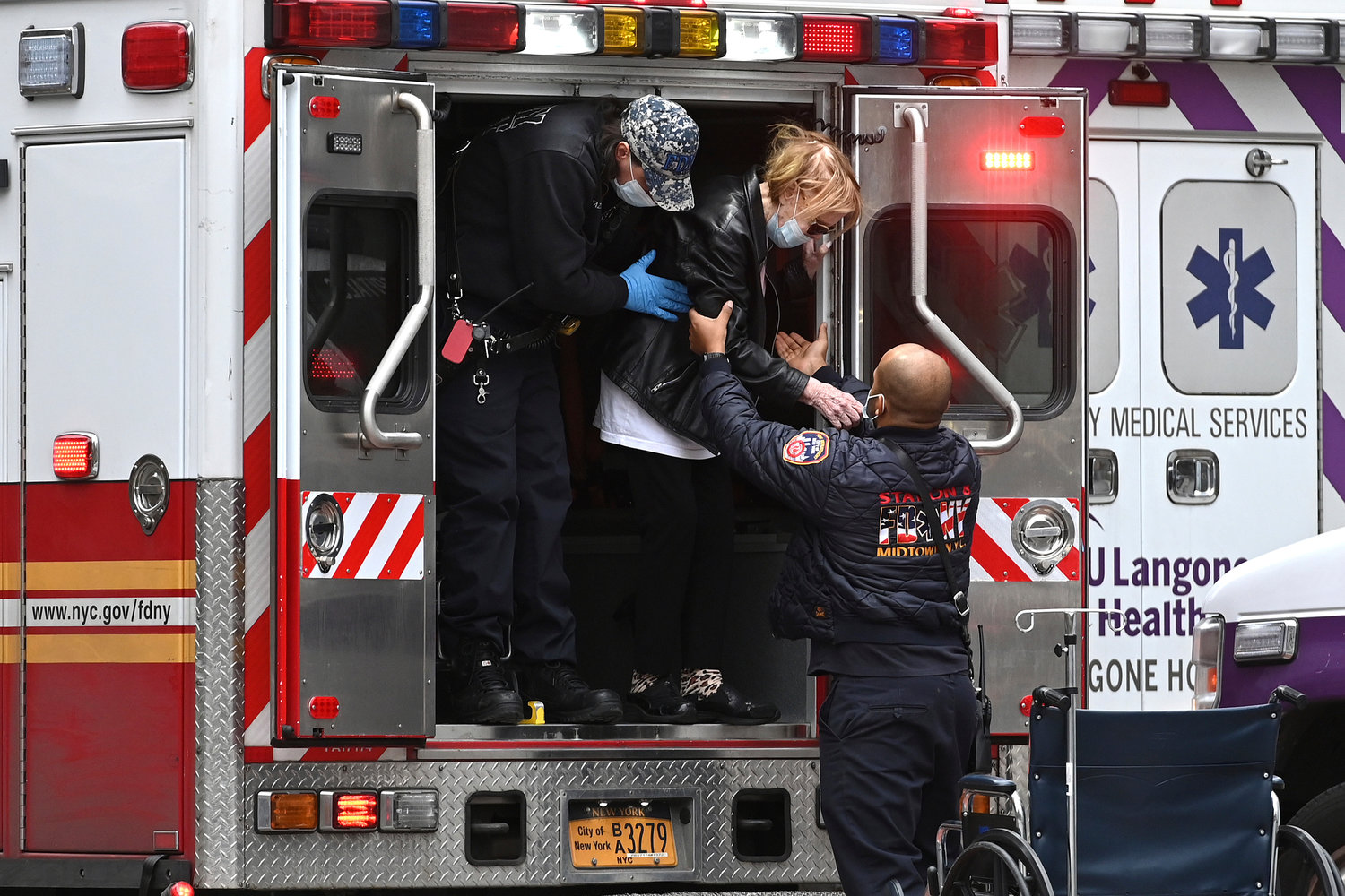 FDNY EMTs assist a patient out of an ambulance outside Manhattan's NYU Langone Health Tisch Hospital in December 2020 during the second wave of covid infections and a record number of hospitalizations.