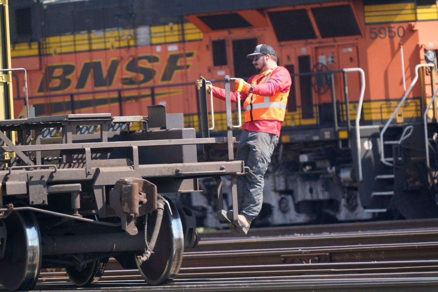 A worker rode a rail car at a BNSF rail crossing in Saginaw, Texas, in September. Most railroad workers weren't surprised that Congress intervened last week to block a railroad strike, but they were disappointed because they say the deals lawmakers imposed didn't do enough to address their quality of life concerns about demanding schedules and the lack of paid sick time.
