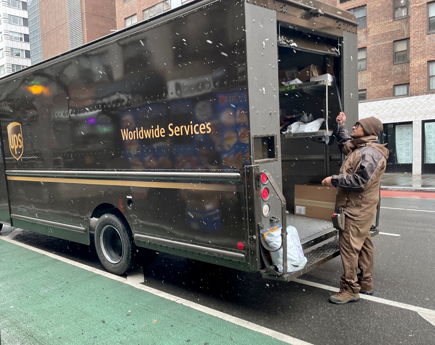 A UPS driver pulled down his truck’s roll-up door following a delivery on the Upper East Side Tuesday. Drivers and other company employees say managers often alter time cards in a manner that cheats the workers from what they are owed.