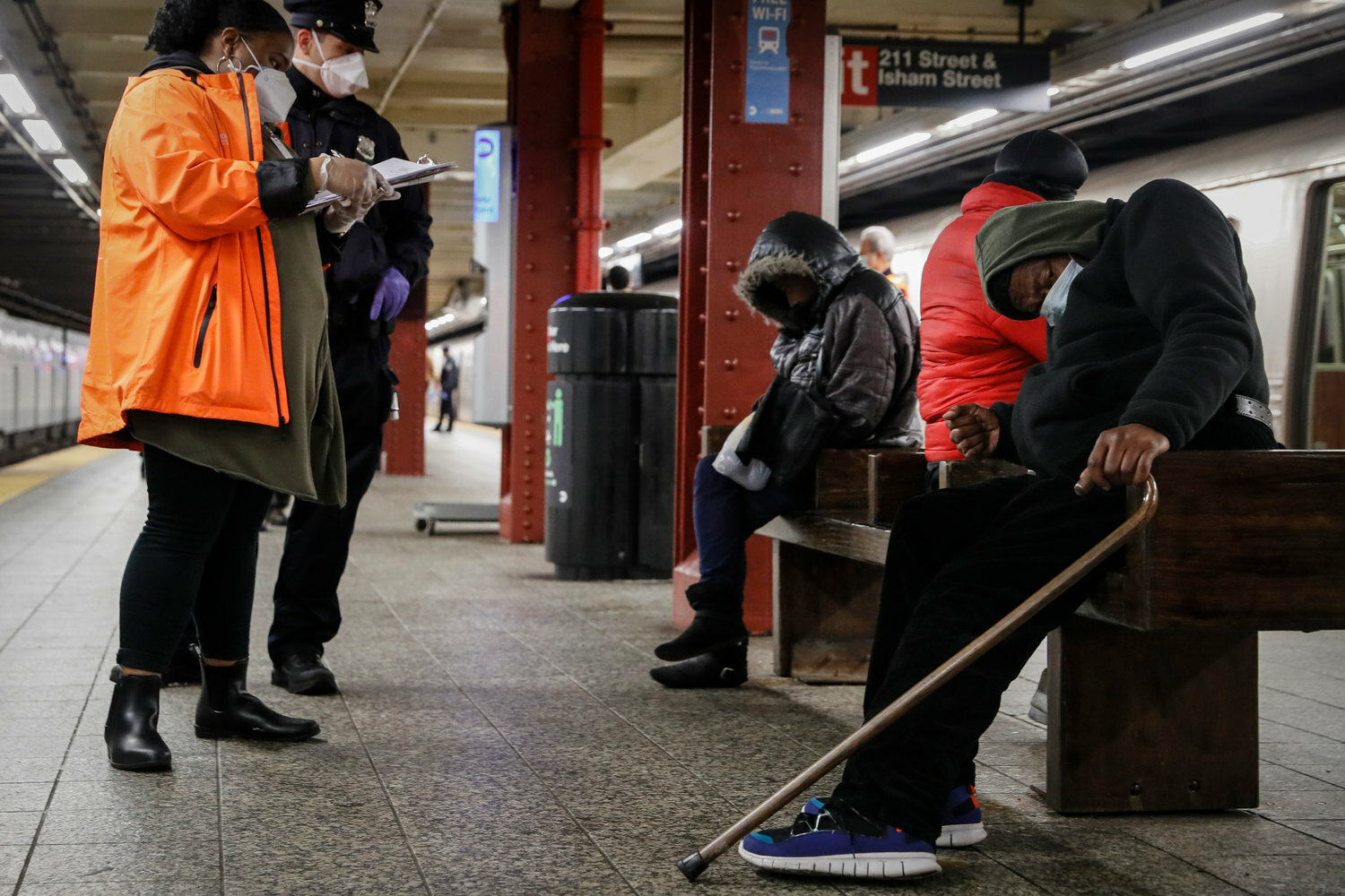 A homeless outreach worker and an NYPD officer assisted passengers found sleeping on subway cars at the 207th Street A train station in Inwood. Mayor Eric Adams last year directed first responders to intervene more aggressively to help people in need of mental health treatment.