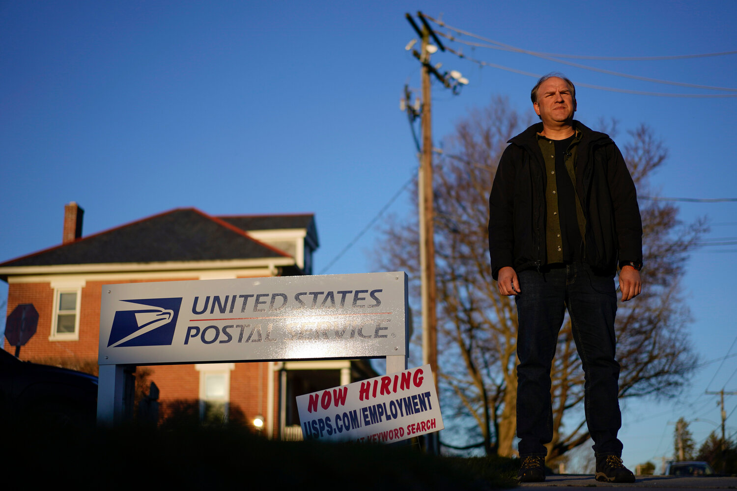 Gerald Groff, a former postal worker whose case is being argued before the Supreme Court, during a March 8 television interview near a "Now Hiring" sign posted at the roadside at the United State Postal Service in Quarryville, Pennsylvania.