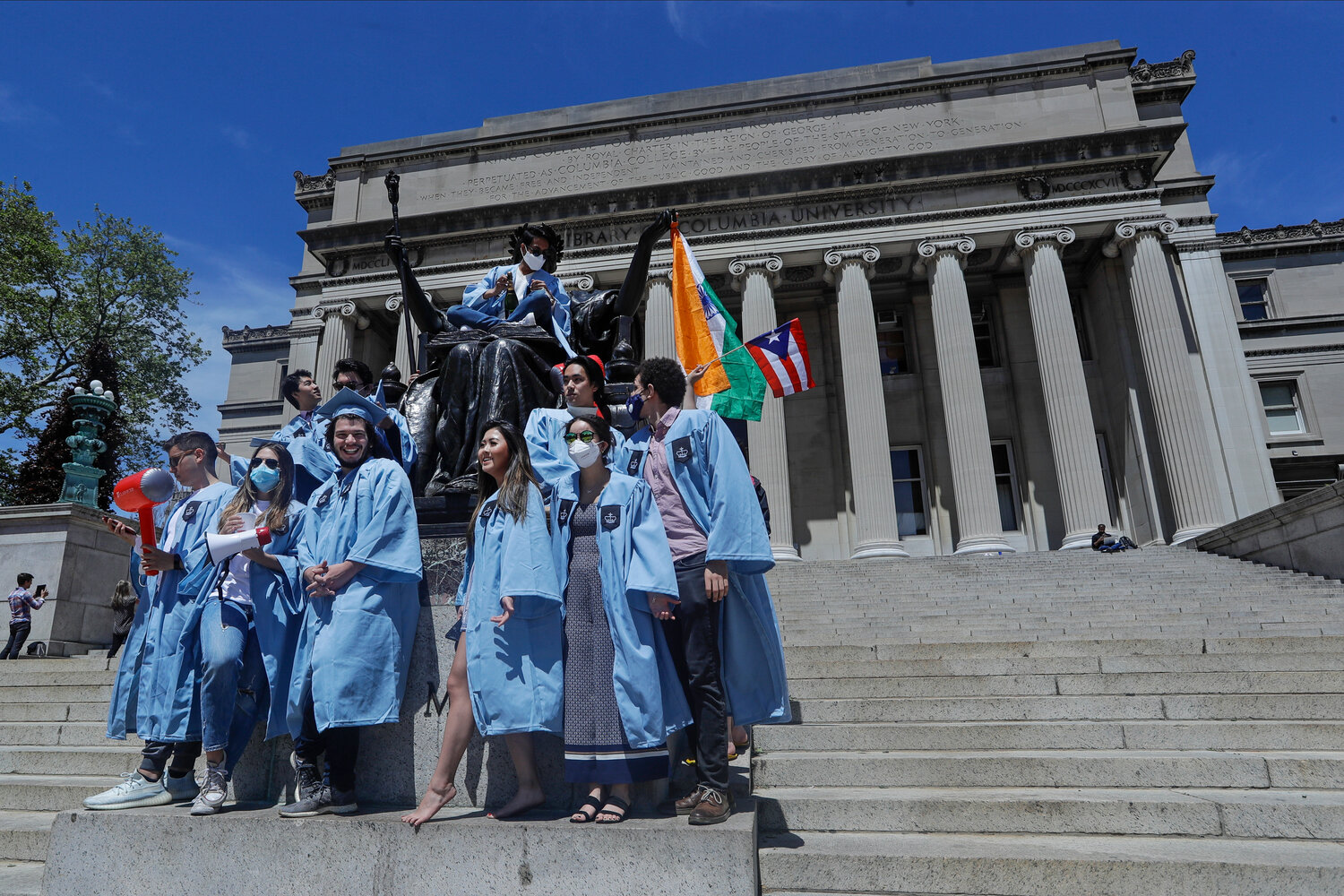 Columbia University graduates posed for celebratory photographs on commencement day in May 2020 in front of the Alma Mater statue near the Low Memorial Library.