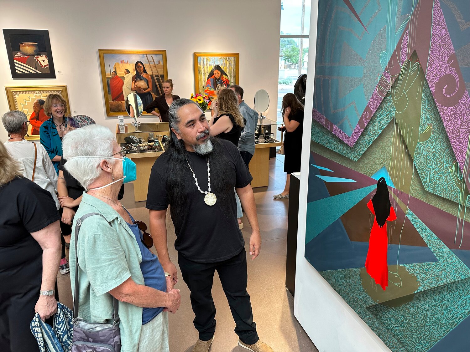 Thomas "Breeze" Marcus at the exhibition opening of his work at Blue Rain Gallery in Santa Fe, N.M. in August, which included the painting "Answered Prayer," at right. A separate group exhibition that included his work was postponed in Arizona amid outrage over a painting by Shepard Fairey that is critical of police.